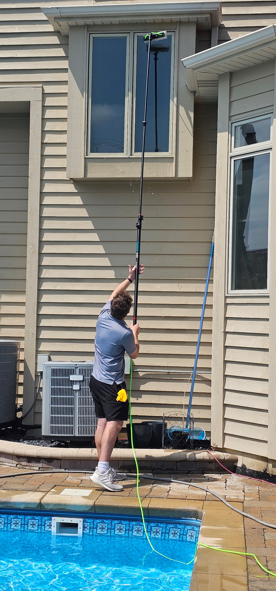 Second-story window cleaning poolside